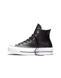 Czarny sneaker za kostkę z białą gumową podeszwą i czarnymi sznurowadłami, widziany z boku na białym tle.