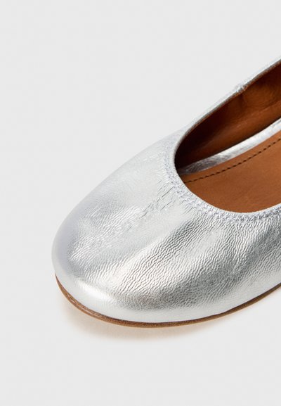 Zilveren ballerina met een gestructureerd, glanzend oppervlak. Voorzien van een ronde neus en een leren inlegzool in bruin. Eenvoudig ontwerp zonder versieringen.