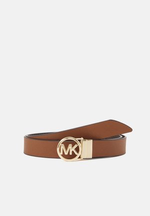 Bruine leren riem met een ronde gouden gesp met de initialen "MK" op een effen lichte achtergrond.