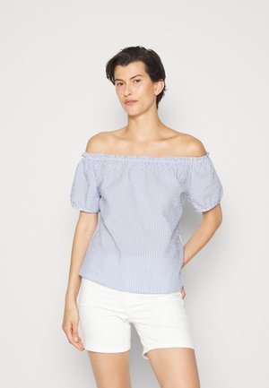 Top off-the-shoulder em azul e branco às riscas, com mangas bufantes e decote elástico, combinado com calções brancos. Tecido em mistura de algodão.