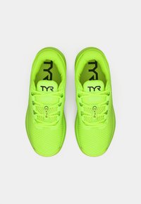 Neonowe zielone buty sportowe z siatkowymi cholewkami, płaskimi sznurowadłami i wyściełanym językiem. Zawierają logo TYR i etykietę CX12 na języku.