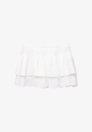 Gonna bianca a strati realizzata in tessuto leggero. Presenta una vita elastica e tre volants sovrapposti, creando una silhouette fluida.