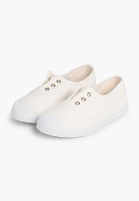 Scarpe slip-on in tela di colore bianco sporco con suola in gomma, dotate di occhielli in metallo e punta testurizzata. Design semplice e privo di ornamenti.