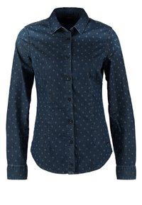 Mörk denimskjorta med långa ärmar, knappstängning, spetsig krage och ett prickigt mönster över hela. Mjuk textur med en figurnära design.