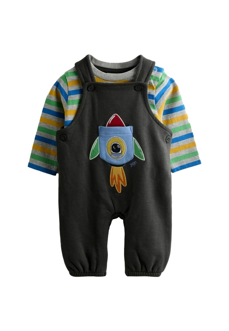 Tamsiai pilkas kombinezonas su spalvingomis dryžuotomis ilgomis rankovėmis, turi kišenę su raketos dizainu ir raudonais bei žaliais akcentais. Minkšta medžiaga, elastingi rankogaliai.