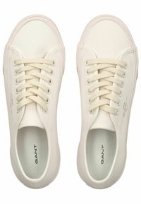 Sneakers bianchi in tela con punta arrotondata e suola piatta in gomma. Presentano lacci abbinati e un sottile logo sul lato.