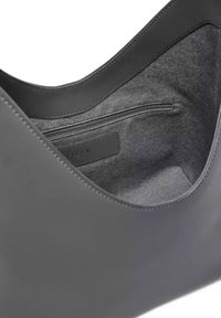 Borsa a spalla in pelle grigia con finitura liscia, dotata di un interno in tessuto morbido e una tasca con zip. Design semplice e arrotondato.