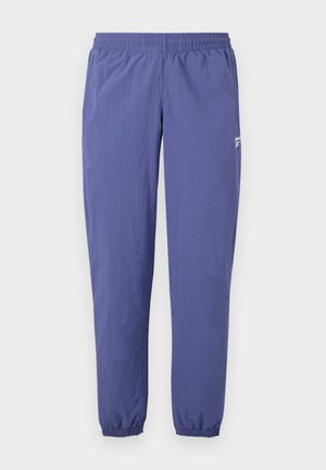 Lilla tuulekindel püksid elastse vöökohaga, kitsenevad jalad, elastsed mansetid ja küljetasku, millel on väike logodetail.
