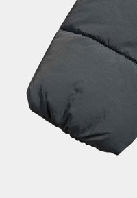 Mörkgrå puffjacka med ärm, som har en samlad elastisk manschett och en slät, något glänsande yta med horisontella sömmar.