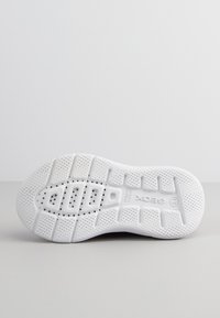 Suela de zapato de goma blanca con superficie texturizada, que presenta un patrón de rejilla, orificios de drenaje y el logotipo de la marca. Diseño plano y redondeado.