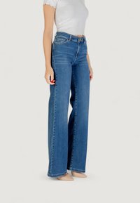 Højtaljede, vidde jeans i blå denim. Har et fem-lommes design og en lys vask med en subtil tekstur.