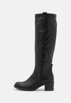Botte noire en cuir montant jusqu'au genou avec un talon bloc bas, un onglet de tirage en haut, et des coutures décoratives le long de la tige et de la cheville.