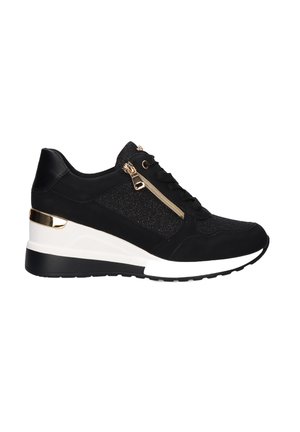 Zapatilla negra con tela texturizada y paneles de cuero, con detalle de cremallera dorada y tacón cuña; media suela blanca y suela negra.