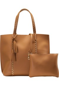 Sac fourre-tout en cuir fauve avec des anses cloutées, un détail de pampille et une pochette zippée assortie supplémentaire. Texture lisse avec une forme structurée.