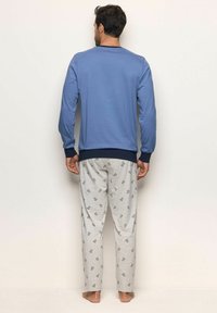 Set di pigiami da uomo composto da una maglietta a maniche lunghe blu con polsini a coste blu scuro e pantaloni grigi con una piccola stampa a motivi.