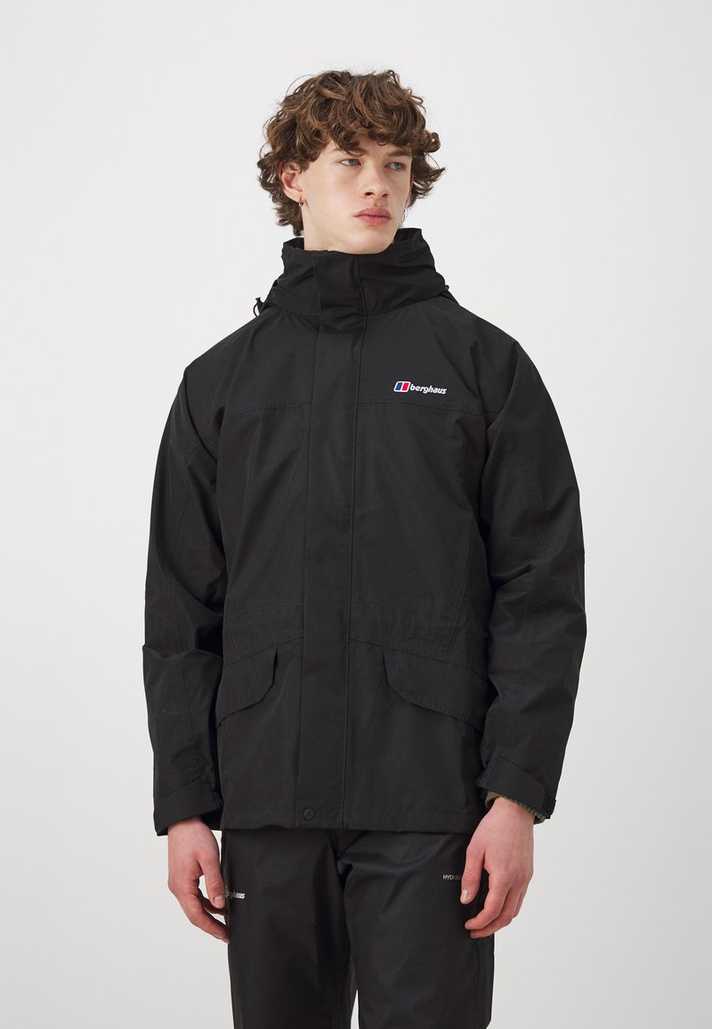 Schwarze wasserdichte Jacke mit hohem Kragen, zwei Fronttaschen und einem Logo auf der linken Brust. Hergestellt aus glattem, strapazierfähigem Material.