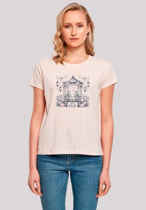 Short-sleeve, pale pink t-shirt featuring a graphic of skeletons sitting under a gazebo with floral accents and lanterns.