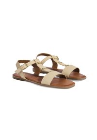 Beige sandalen met gestructureerde banden, een platte zool en gouden gespen. Het ontwerp omvat brede en slanke banden voor ondersteuning.