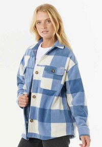 Blauw-wit geruite fleece shirtjack met een kraag, knoopsluiting aan de voorkant en een enkele borstzak. Zachte textuur met een ontspannen pasvorm.