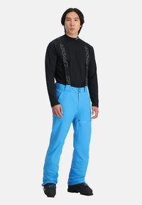 Blaue Skihosen mit verstellbaren schwarzen Hosenträgern, ausgestattet mit einer Reißverschlusstasche an der Seite, aus einem wasserabweisenden Material.