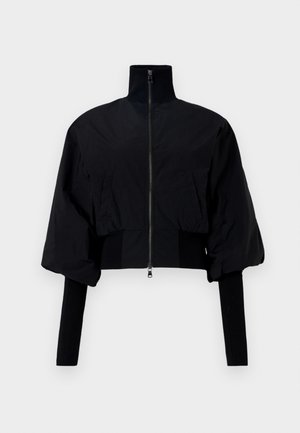 Schwarze verkürzte Jacke mit hohem Kragen, Reißverschluss und Puffärmeln. Verfügt über Jerseyeinsätze an den Bündchen und am Saum. Glatte Textur.