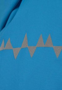 Tessuto blu testurizzato con un motivo a zigzag grigio che attraversa orizzontalmente il centro. Il materiale sembra resistente e resistente alle intemperie.