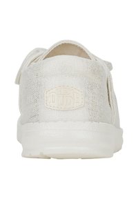 Chaussure slip-on en tissu texturé blanc avec un talon ferme et une semelle en caoutchouc. Présente un patch logo à l'arrière et un design léger.