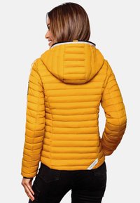 Gevoerde gele jas met horizontale stiksels, een capuchon en zwarte accenten. Heeft een witte rits en een logo-label op de zoom.