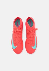 Klart röda sportskor med turkosa Nike-swoosh-loggor, snörda, och "Mercurial"-texten synlig inuti skorna.