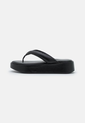 Sort flip-flop sandal lavet af glat læder med en tyk platformssål, der har et minimalistisk design og en mellemrumstrop.