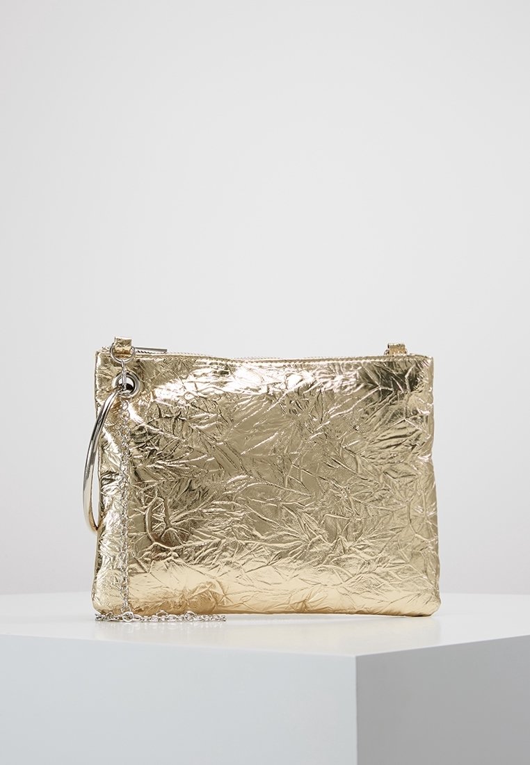 Złota torebka kopertowa o pogniecionej fakturze z gładkim metalicznym wykończeniem, zamek błyskawiczny oraz odczepiany łańcuszek, oferujący różne opcje noszenia.