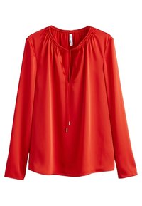 Blusa roja de manga larga con cuello redondo, detalles fruncidos y una abertura en forma de lágrima. Fabricada con un tejido liso y brillante.