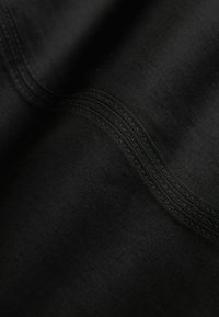 Un material textil black, cu o textură netedă, având cusături subtile pe suprafață, care creează un model în valuri.