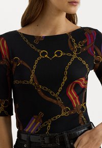 Top negru cu lanțuri aurii, modele de hamuri maro și accente violet și roșu pe mânecile scurte. Țesătură netedă cu o formă strânsă.