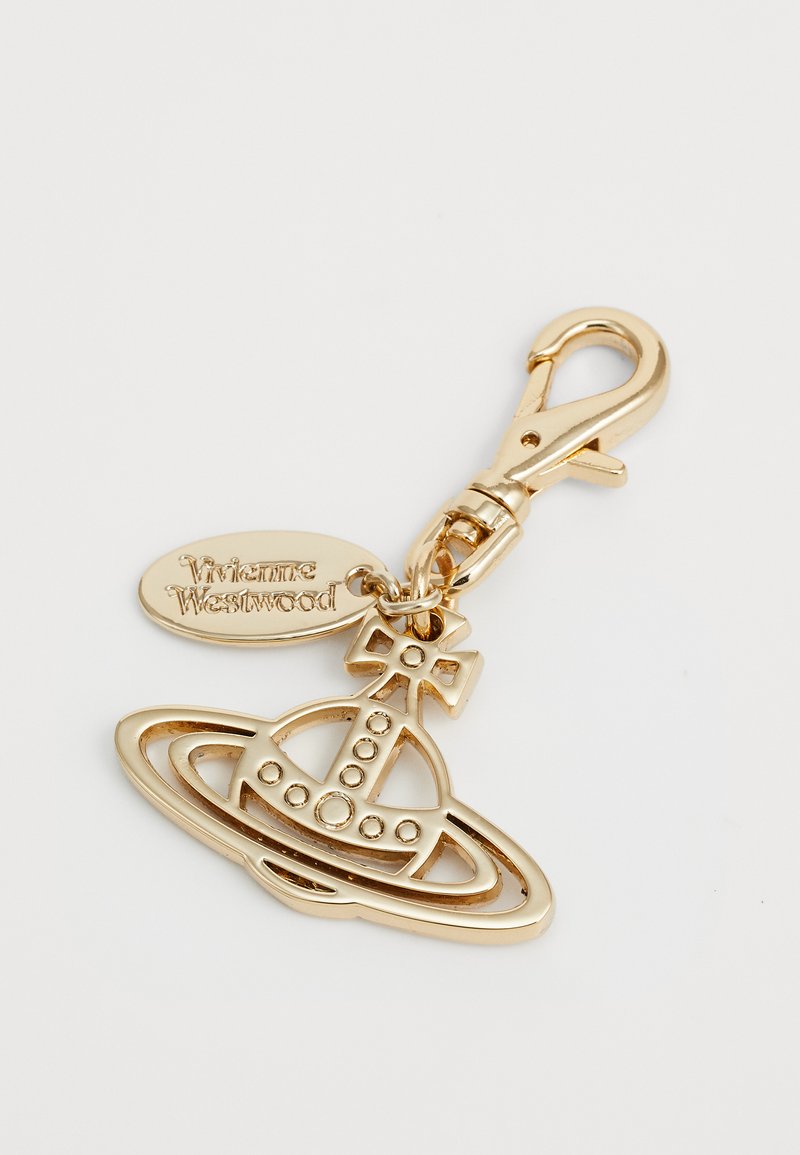 Portachiavi in metallica dorato con un design di Saturno, un piccolo accento a croce e un'etichetta inciso con "Vivienne Westwood."