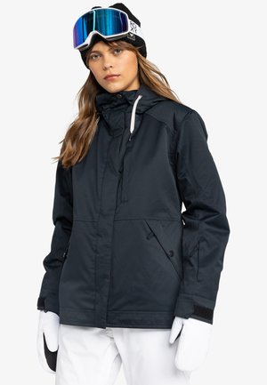 Chaqueta de esquí azul oscura con capucha y cordones, que cuenta con dos bolsillos frontales, cierre de cremallera, y se combina con guantes blancos y pantalones de nieve.
