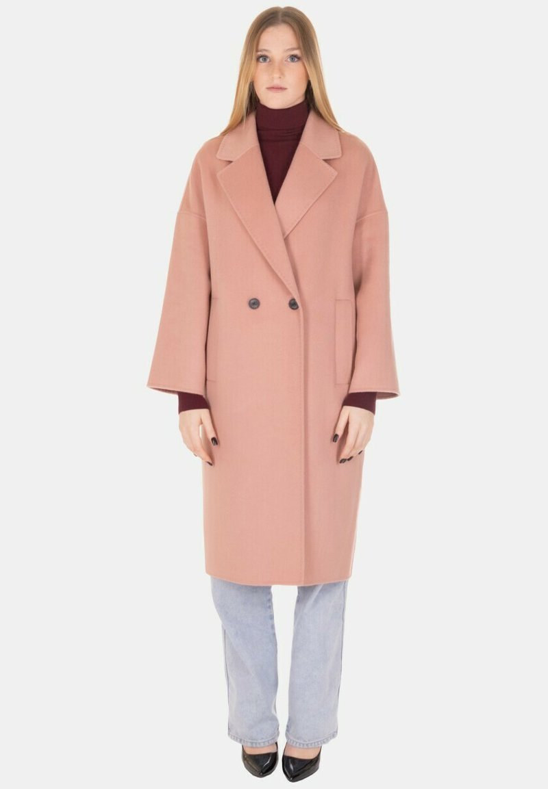 Cappotto doppiopetto in tessuto rosa tenue. Presenta un colletto appuntito, maniche oversize e una tasca singola. Bottoni neri valorizzano il design.
