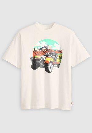 T-shirt bianco con una stampa grafica di un veicolo fuoristrada giallo e nero davanti a un paesaggio Desertico colorato e a un cielo blu.