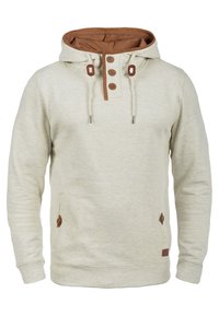 Felpa grigia chiaro realizzata in materiale morbido con cappuccio foderato in marrone, tre bottoni decorativi e tasche laterali, caratterizzata da un accento in pelle.