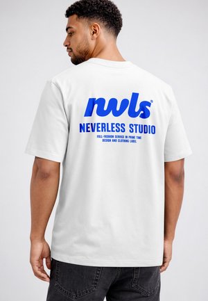 Mann trägt weißes T-Shirt mit blauem Text "nwls NEVERLESS STUDIO" und kleinerem Text darunter auf dem Rücken, steht vor einfachem hellem Hintergrund.