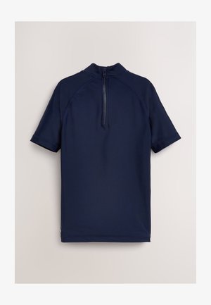 Laivastonsininen lyhythihainen uimapaita, jossa on korkea kaulus ja selän vetoketjusulku. Valmistettu sileästä, joustavasta materiaalista, jossa on litteät saumat.