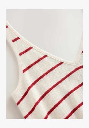 Raidallinen neuletanktopaita, jossa on V-pääntie, punaisia ja beigejä raitoja. Pehmeä rakenne ja kevyt materiaali.