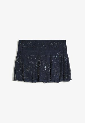 Jupe plissée bleu marine foncé avec des embellissements en sequins et perles créant un motif subtil en spirale sur une superposition de tissu transparent.