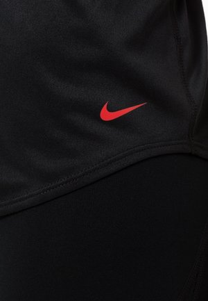Shorts de sport noirs en tissu lisse avec un logo Nike rouge. Présente un design ajusté et des coutures plates pour le confort et la durabilité.