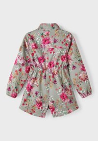 Blommönstrad jacka i dämpat grönt, med rosa och lila blommor, elastisk midja och långa ärmar med samlade manschetter.