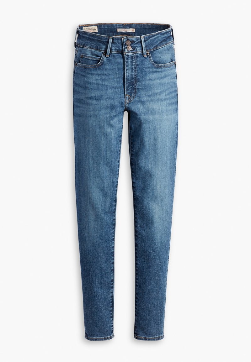 Jean slim bleu taille haute avec fermeture à boutons à l'avant, cinq poches, et légère décoloration sur les cuisses et les genoux.