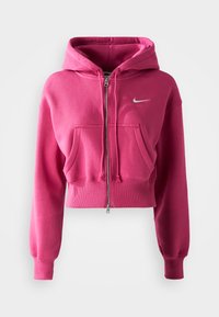 Ružový skrátený mikina z mäkkej tkaniny, s kapucňou a zipsom, prednými vreckami a malým bielym logom Nike na hrudi.