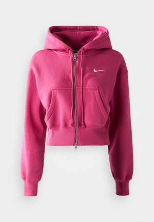Roze cropped hoodie van zachte stof, met een ritsopening, vo pockets aan de voorkant en een klein wit Nike-logo op de borst.