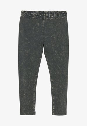 Črne denim legice s pošvedrano površino, ki imajo elastičen pas in ozek kroj. Tekstura prikazuje subtilne razlike.