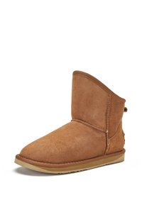 Bota de tobillo de ante color marrón claro con una textura suave, punta redondeada, costuras decorativas y una suela de goma de perfil bajo. Sin hardware ni acentos visibles.